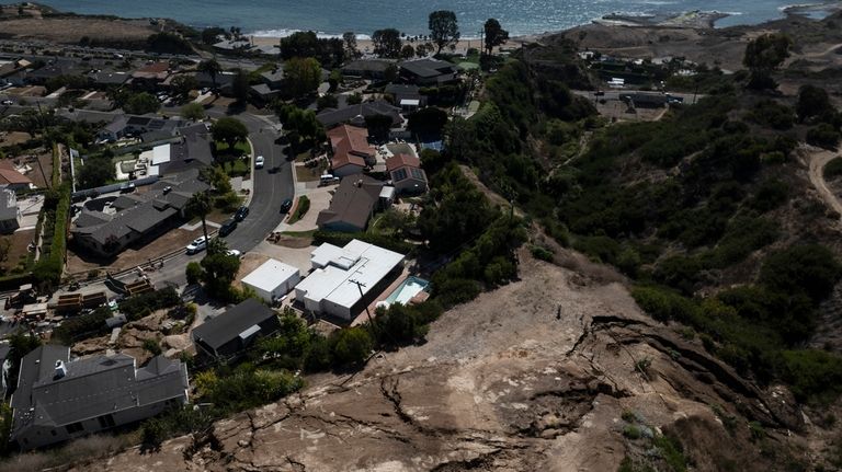 An aerial view shows a neighborhood damaged by ongoing landslides...