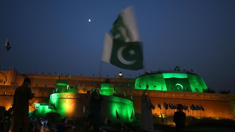 A Pakistani waves national flag in front of the 'Bala...