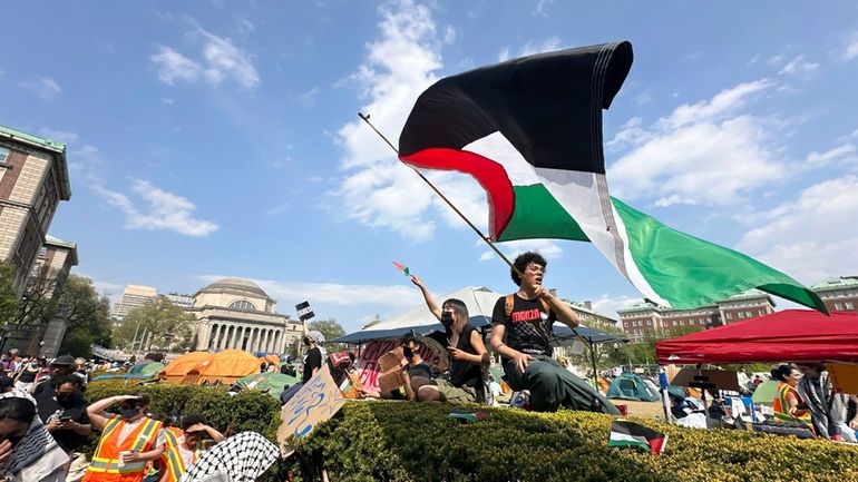 A demonstrator waves a flag on the Columbia University campus...