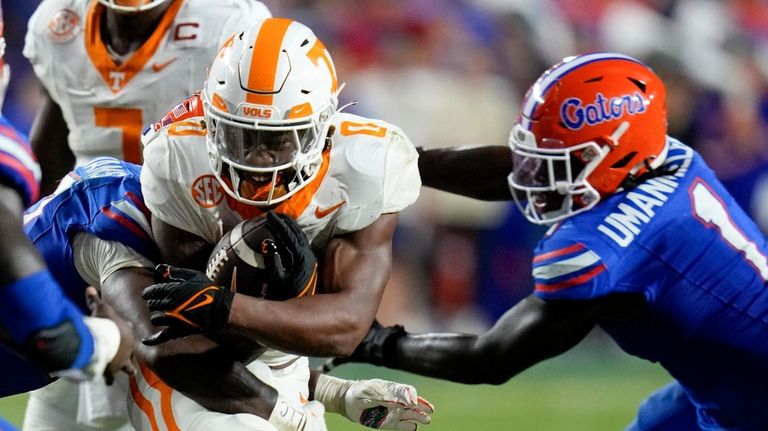 Tennessee running back Jaylen Wright, center, is stopped by Florida...