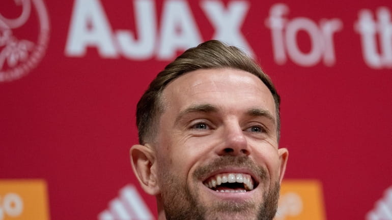 England midfielder Jordan Henderson laughs during a news conference in...