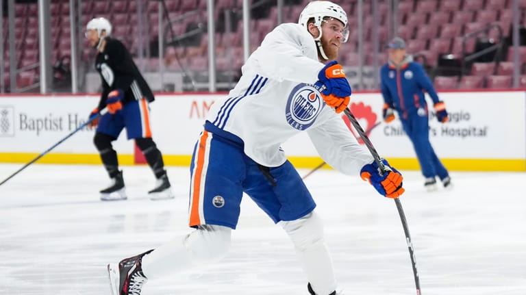 Edmonton Oilers forward Connor McDavid, foreground, shoots during practice Sunday,...