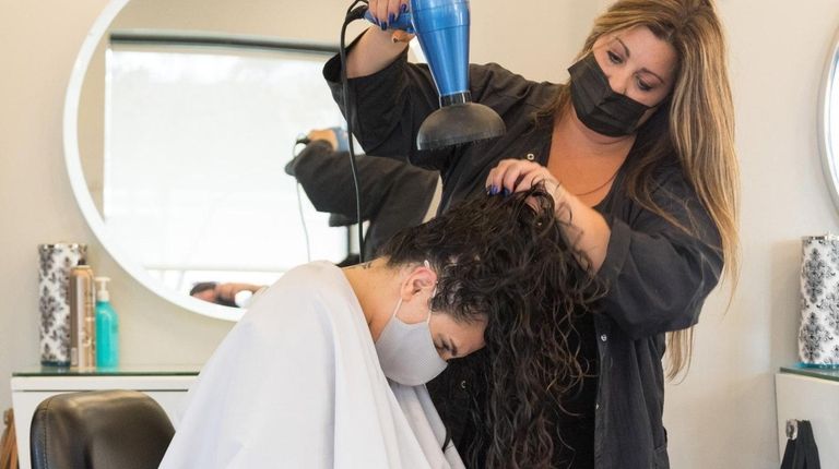 Senior Stylist Jessica Sotis dries the hair of Samantha Lotfi...