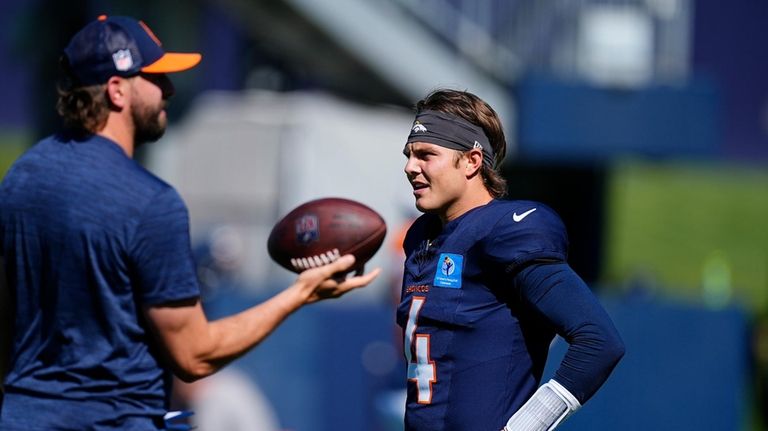 Denver Broncos quarterbacks coach Davis Webb, left, chats with quarterback...