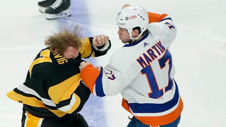 The Islanders' Matt Martin fights with the Penguins' John Ludvig during...