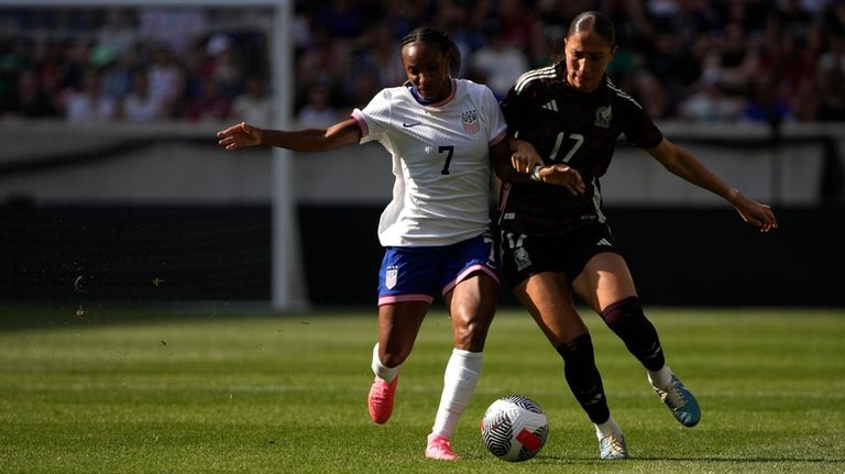 United States forward Crystal Dunn, left, battles for the ball...