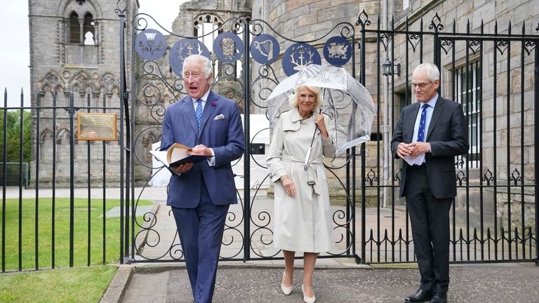 Britain's King Charles III, left, and Queen Camilla, center, accompanied...