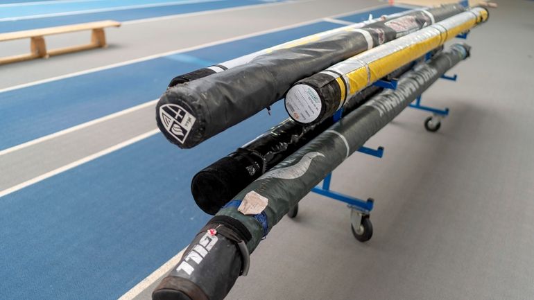 Pole vault luggage bags sit on the track at the...