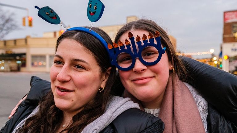 Sisters Chana, left, and Yehudis Heber of Brookville celebrate Hanukkah at...