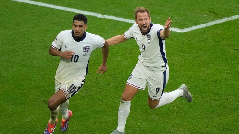 England's Jude Bellingham, left, celebrates with Harry Kane after scoring...
