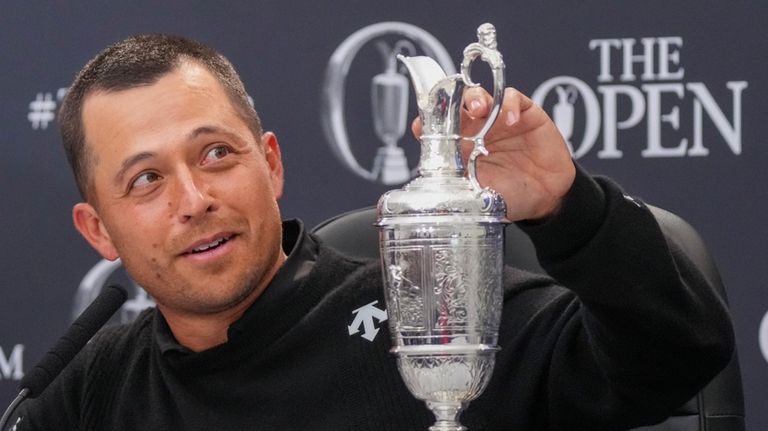 Xander Schauffele of the United States touches the Claret Jug...