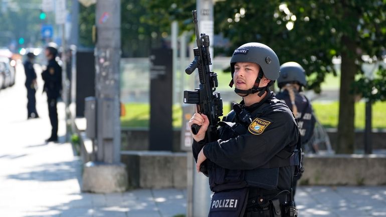 Police officers patrol near a scene after police fired shots...