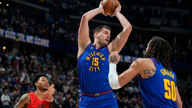 Denver Nuggets center Nikola Jokic, center, pulls in a rebound...