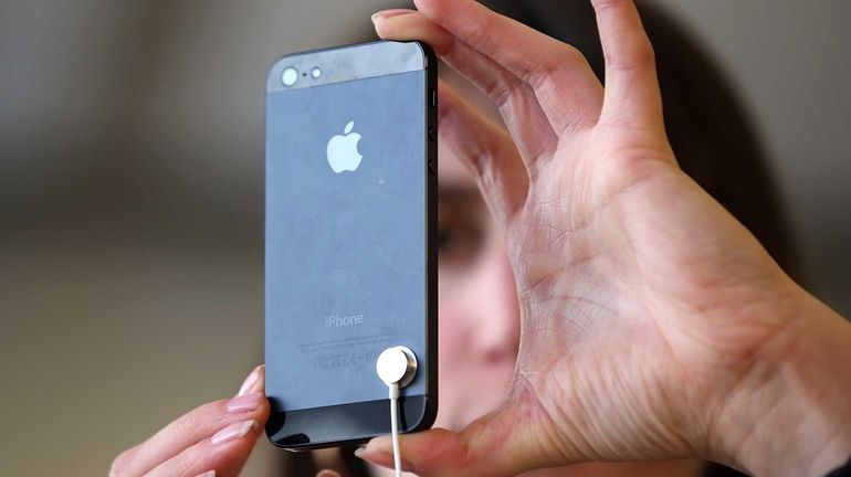 A customer inspects the new iPhone 5 at an Apple...