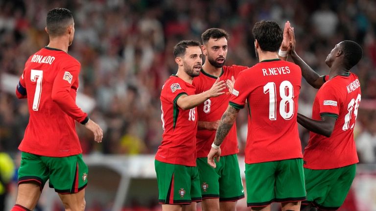 Portugal's Bruno Fernandes, centre, celebrates after scoring his side's first...