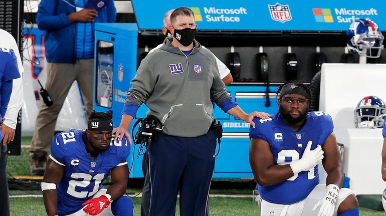 Giants head coach Joe Judge stands with Jabrill Peppers #21...