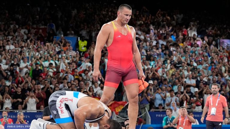 Turkey's Taha Akgul celebrates after defeating Kyrgyzstan's Aiaal Lazarev in...