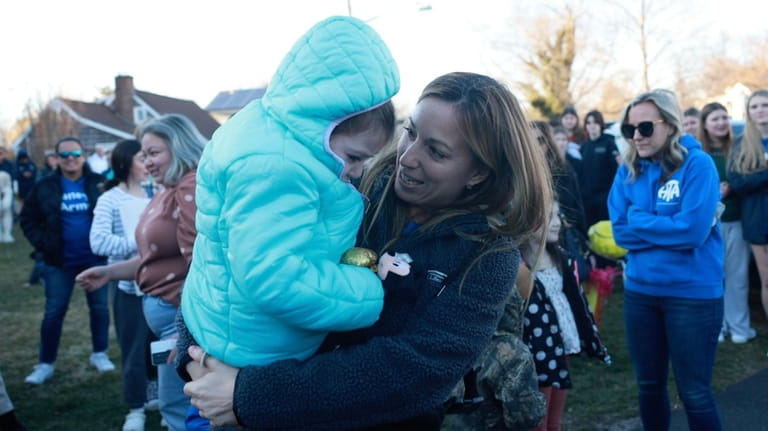 Tiffany Rowan holds her daughter Laney McGowan, 6, as they...