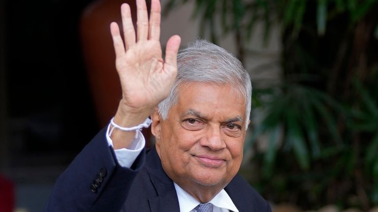 Sri Lanka's President Ranil Wickremesinghe waves to the media as...