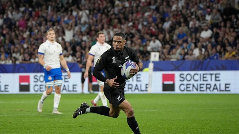 New Zealand's Aaron Smith runs to score a try during...