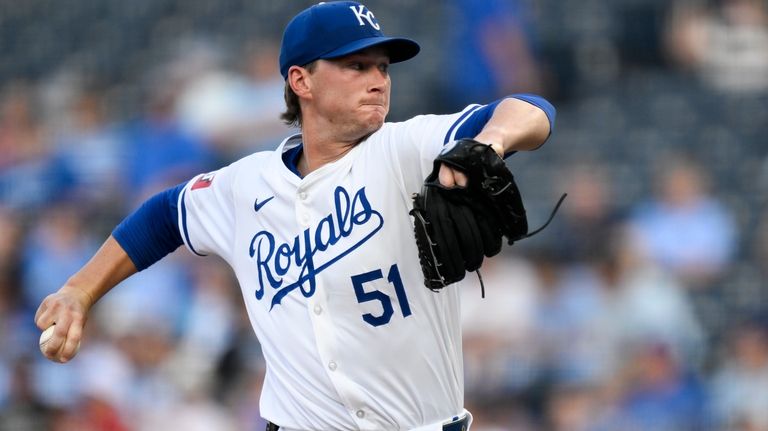 Kansas City Royals starting pitcher Brady Singer (51) throws to...