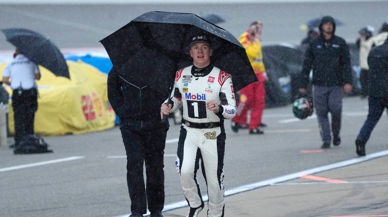 John Hunter Nemechek runs to the team trailer after rain...