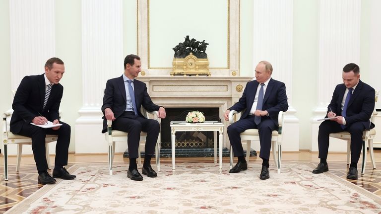 Syrian President Bashar Assad, second left, speaks with Russian President...