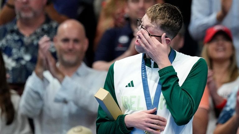 Gold medalist Daniel Wiffen, of Ireland, wipes his eye while...