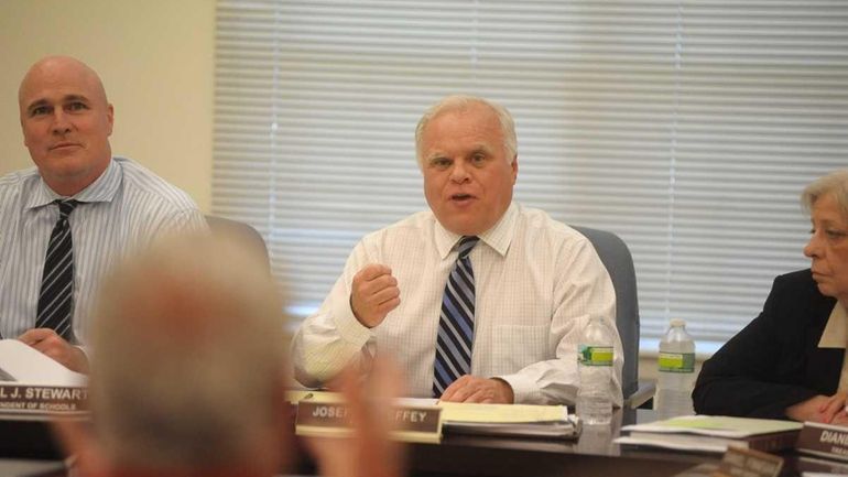 President of the Center Moriches school board, Joseph McHeffey (center)...