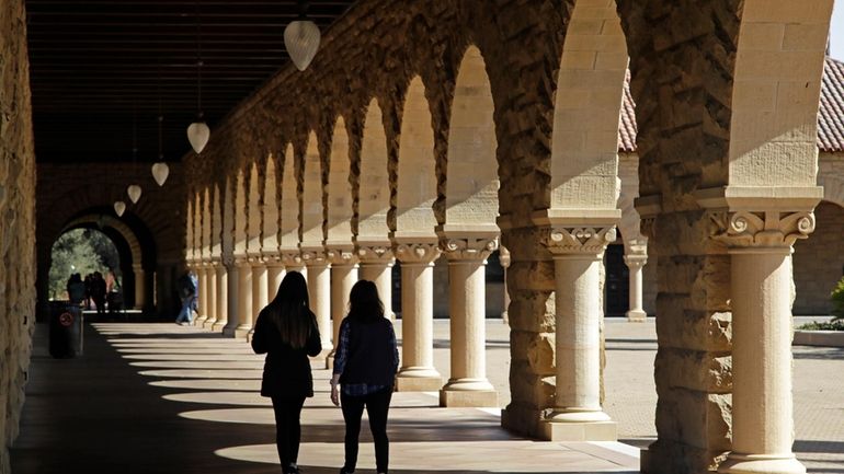 In this March 14, 2019, file photo students walk on...