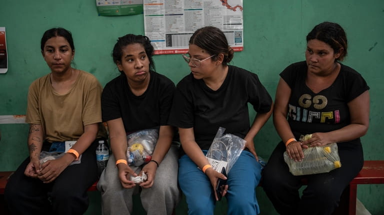 Venezuelan migrant Yeneska Garcia, second from left, sits with other...