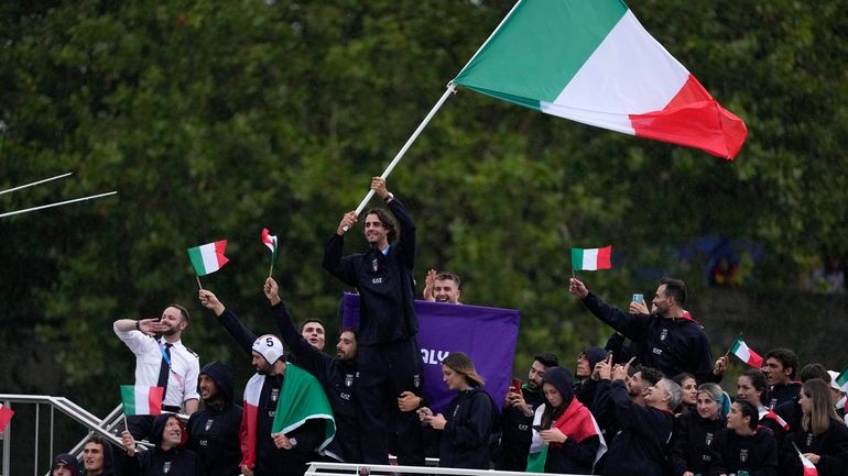 Gianmarco Tamberi waves an Italian flag as the Italian team...