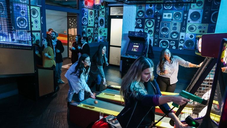 Patrons play a variety of arcade games at Standard Rec...