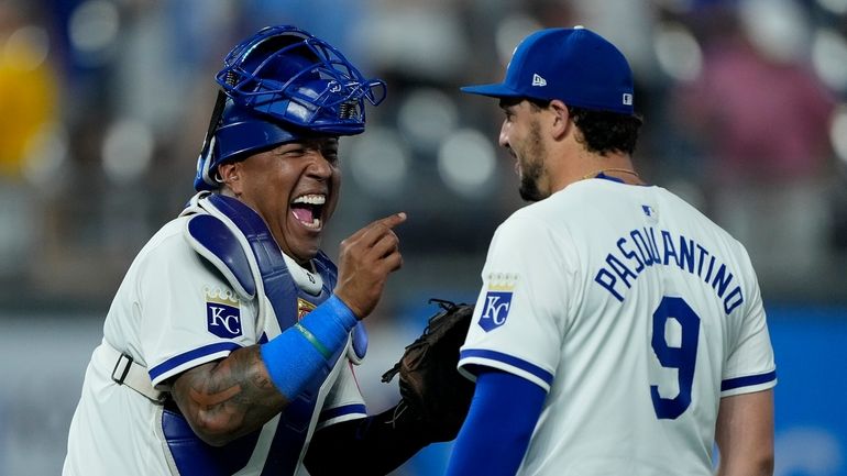 Kansas City Royals' Salvador Perez, left, celebrates with Vinnie Pasquantino...