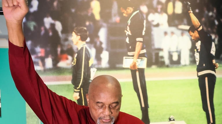 American former track and field athlete Tommie Smith reenacts his...