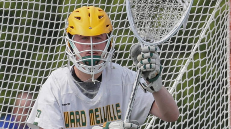 Collin Krieg #28 of Ward Melville defends the net during...