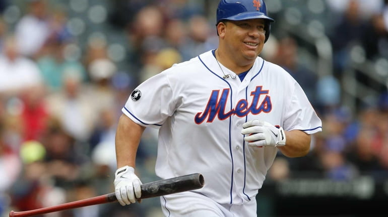 Bartolo Colon of the Mets runs with his bat after...