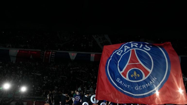 Paris Saint Germain flag is waved as players celebrate PSG's...