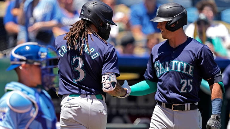 Seattle Mariners' J.P. Crawford (3) celebrates with Dylan Moore (25)...