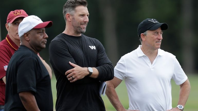 Washington Commanders owner and managing partner Josh Harris, right, watches...