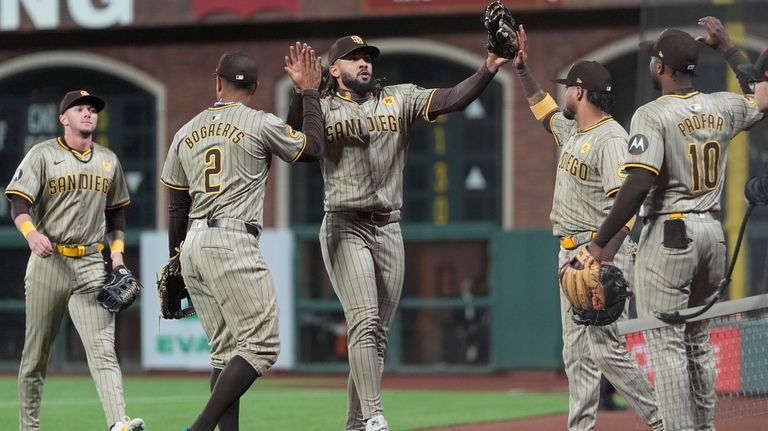 San Diego Padres right fielder Fernando Tatis Jr., middle, celebrates...