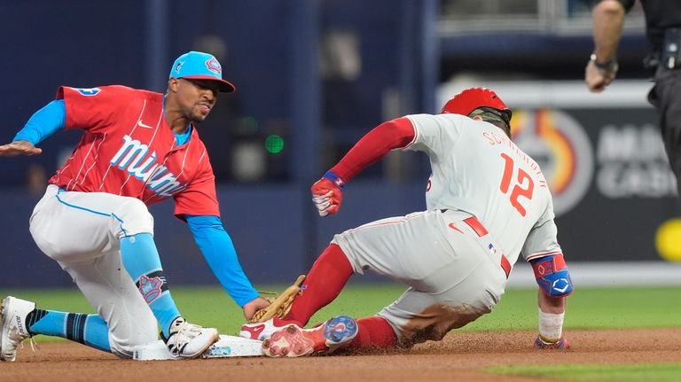 Philadelphia Phillies' Kyle Schwarber (12) slides into second base as...