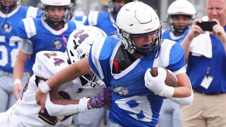 New Hyde Park quarterback Aidan Garvey tries to break free from...