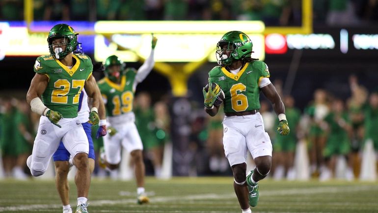 Oregon running back Noah Whittington (6) runs the ball for...