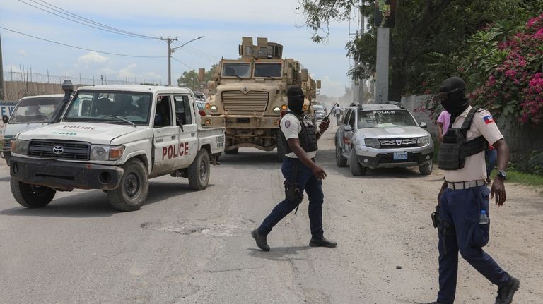 Police officers patrol a street near the airport in Port-au-Prince,...