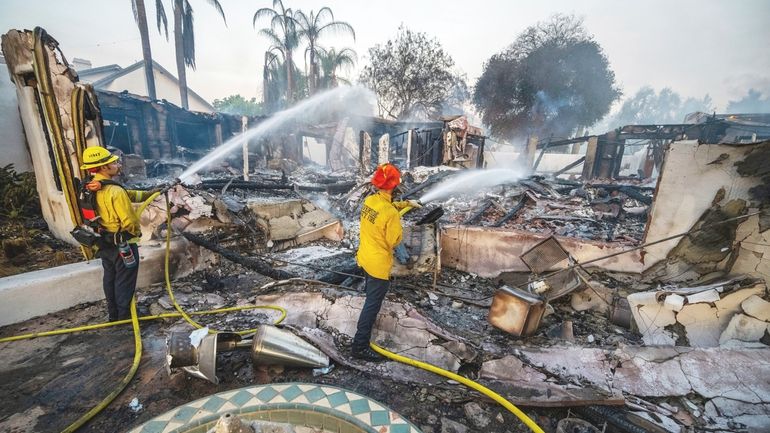 Firefighters hose down hot spots at Noel Piri's home that...