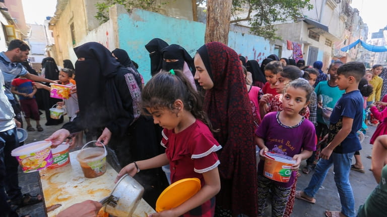 Palestinians receive food in Rafah, southern Gaza Strip, Wednesday, Nov....