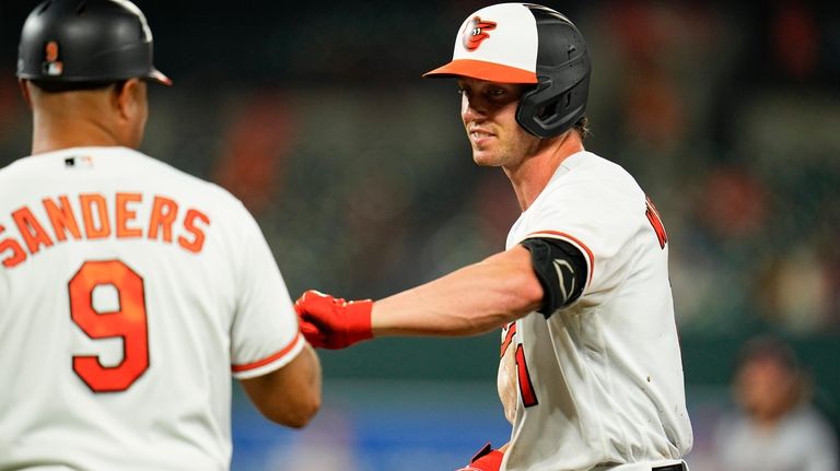 Baltimore Orioles' Jordan Westburg, right, reacts with first base coach...