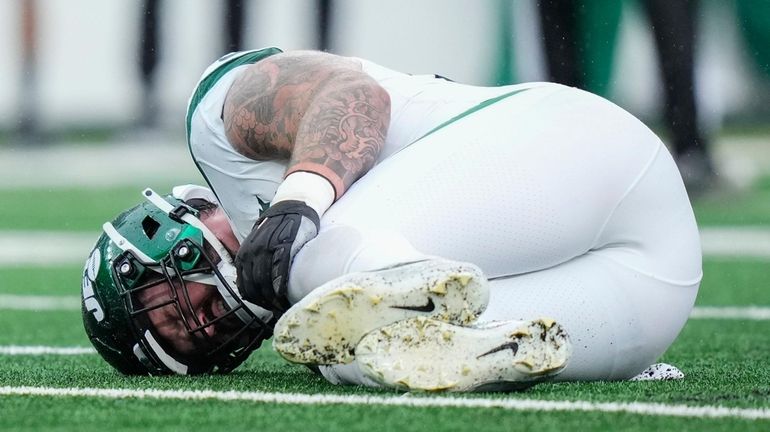 Jets center Connor McGovern lies on the field with an injury during...