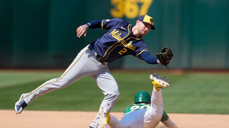 Oakland Athletics' Zack Gelof, bottom, steals second base against Milwaukee...